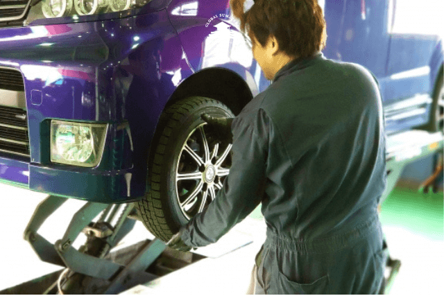 Mekanik mobil mengganti ban mobil di Jepang.