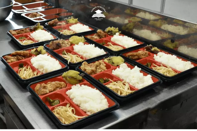 siswa tokutei ginou yang bekerja di pabrik produksi makanan membuat makan siang kemasan.